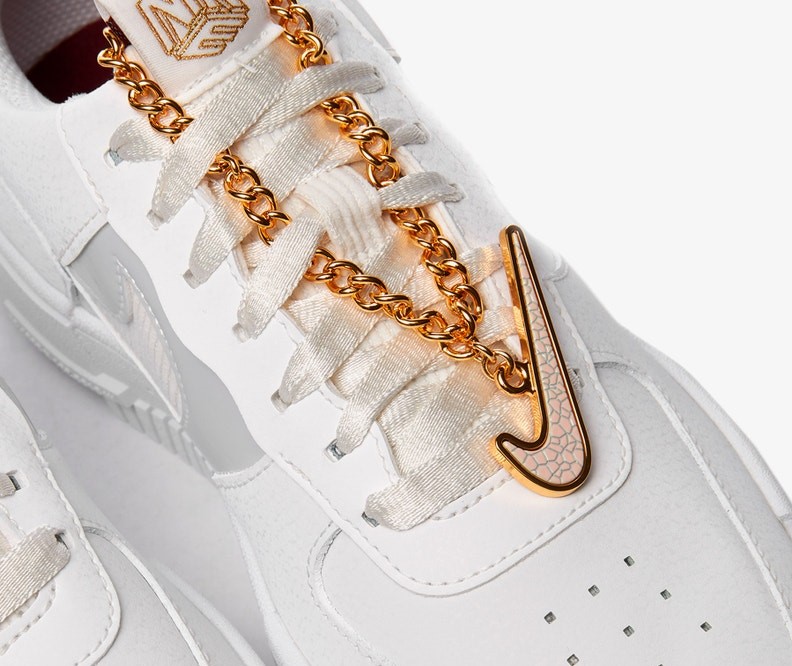 white nike shoes with gold check